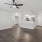 Two-Bedroom Apartments in North Naples, FL - Meadow Brook Preserve - Open Layout Living Room with Vinyl Plank Flooring, Ceiling Fan, White Closets with Louver Doors, and View of Kitchen.
