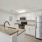Three-Bedroom Apartments in North Naples, FL - Meadow Brook Preserve - Kitchen with Vinyl Plank Flooring, Granite Countertops, Dual Sinks, Stainless-Steel Appliances, and White Cabinetry.